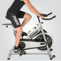 a woman is riding an exercise bike on a white background with the words spinning in front of her