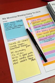 a notebook with sticky notes and a pen