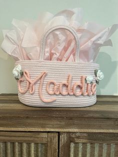 a pink basket with the word nadda written in cursive letters on it