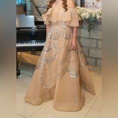 a woman standing in front of a piano wearing a dress with sequins on it