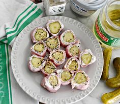 a white plate topped with cucumbers next to pickles and other food items