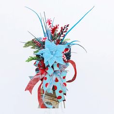 a red, white and blue bow on top of a vase filled with flowers