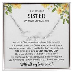 a necklace with the words sister on it and yellow flowers in front of an open box