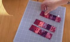 someone is cutting out small pieces of fabric