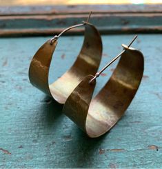 These sweet, wide brass hoops make great "every day" earrings. Hammered and oxidized, sterling ear wire fits into hole in back of hoop to close. Small - around 3/4" diameter Medium - 1 1/2" diameter Large - a little over 2" diameter Artisan Oxidized Hoop Earrings, Vintage Brass Small Hoop Earrings, Vintage Small Hoop Brass Earrings, Artisan Hoop Earrings With Oxidized Finish, Small Bronze Metal Hoop Earrings, Adjustable Brass Vintage Hoop Earrings, Vintage Brass Round Hoop Earrings, Brass Hoop Wrap Earrings, Adjustable Vintage Brass Hoop Earrings