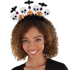 a woman wearing a halloween headband with skulls and bats on it's top