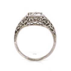 an antique style diamond ring with filigrees on the sides and a square center stone