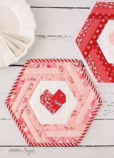 two quilted coasters sitting next to each other on a white wooden table top