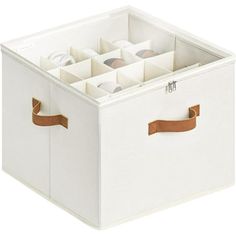 a white storage box with brown handles and compartments on the bottom is filled with empty items