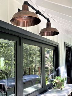 two lights hanging from the ceiling above a window