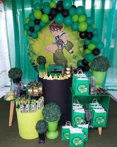 a table filled with green and black balloons, potted plants and other items on top of it