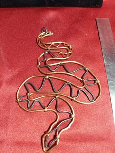 a pair of scissors sitting on top of a red cloth next to some metal wire