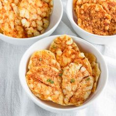 three bowls filled with food on top of a white table cloth next to each other