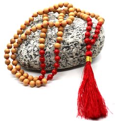 Welcome, Namaste  Description Description :This genuine sandalwood mala is used for japa (repeating mantras or A). This mala is made from genuine naturally fragrant sandalwood and will never loose its aroma. Using the very best quality sandalwood. Alsp featuing in this mala is Red Coral beads with beautiful red knots and long tassel. Total no. beads 108+1 Bead  Bead size -6 mm approx. Length of mala - 75 cm approx In India Sandalwood is given divine status and is thus very commonly used in mala Spiritual Wooden Beads Mala For Meditation, Holistic Healing Mala With Wooden Beads, Holistic Wooden Beads Mala For Rituals, Holistic Wooden Mala For Rituals, Handmade Red Mala For Healing, Red 8mm Beads Spiritual Mala, Spiritual Wooden Beads Mala For Puja, Red Hand-strung Spiritual Mala, Red Round Beads Mala For Meditation