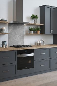 a kitchen with gray cabinets and wooden floors