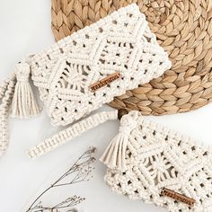 two white crocheted bags sitting on top of a table next to a straw hat