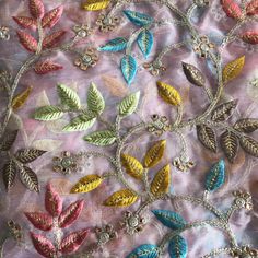 an embroidered fabric with colorful leaves on it