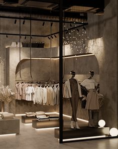 a store display with mannequins and clothes hanging from the ceiling in front of it