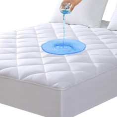 someone is pouring blue liquid on a mattress