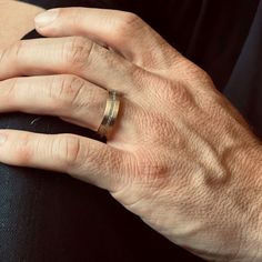 a close up of a person's hand with a ring on it