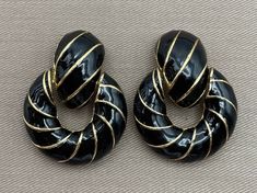 "Massive CINER Signed Enamel Doorknocker Clip On Statement Earrings c. 1980s -Glossy black enamel swinging doorknocker clip earrings with shiny gold tone metal stripes -Signed Ciner -Great vintage condition with age appropriate wear -Each measures approximately 1 7/8\" long x 1 3/8\" wide" Luxury Statement Clip-on Earrings With Polished Finish, Luxury Statement Earrings With Black Enamel, Black Tissue Paper, Cardboard Jewelry Boxes, Clip Earrings, Matte Gold, Black Enamel, Gold Tone Metal, Photo Jewelry