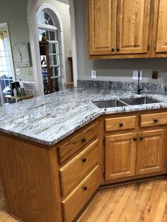 a kitchen with wooden cabinets and marble counter tops