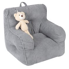 a teddy bear is sitting in a grey corded chair