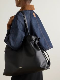 Though this tote is a relatively recent addition to Loewe's 'Flamenco' line, the style is nothing short of iconic. Introduced in the '70s, it's defined by the drawstring closure that creates supple folds in the leather, almost as if it were silk. This 'XL' version has been made in Spain, stamped with the house's 'Anagram' and lined in herringbone fabric. Loewe Flamenco Bag Outfit, Loewe Flamenco Bag, Loewe Tote Bag, Loewe Flamenco, Dream Bags, Herringbone Fabric, Loewe Bag, Sports Trousers, Sport Swimwear