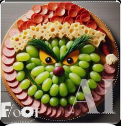 a plate with grapes, ham and cheese as the face of an evil clown on it