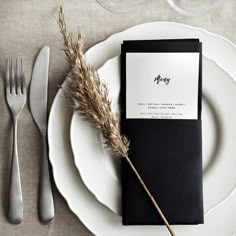 a place setting with silverware and black menu cards