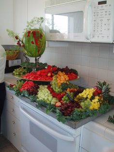 a woman standing in front of a counter filled with fruits and vegtables