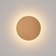 a circular light that is mounted on the side of a wall in a white room