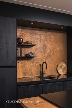 a kitchen with black counter tops and wooden shelves on the wall, along with a sink