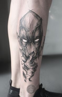 a man's leg with a black and white tattoo design on the side of his leg