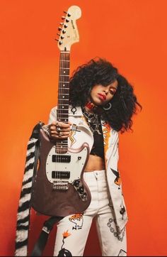 a woman holding an electric guitar in her hands