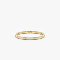 a yellow gold ring with white diamonds on the inside and outside, set against a plain background