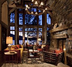 a living room filled with lots of furniture and a fire place in front of a large window