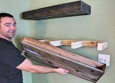 a man is holding some wood planks in his hand while standing next to the wall