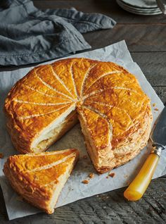 a pie with one slice cut out on top of it next to a knife and fork