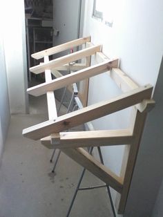 three pieces of wood sitting on top of a metal stand next to a white wall