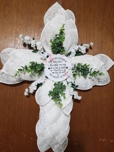 a cross made out of burlocks with flowers on it