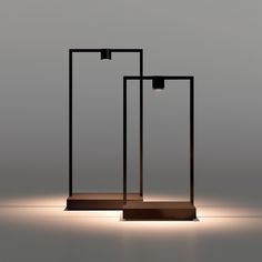 two black lamps sitting on top of a wooden stand in the middle of a room