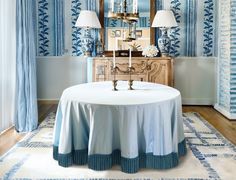 a dining room with blue and white wallpaper, table cloths and two lamps