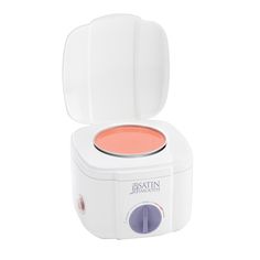 an electric waxing machine with the lid open and pink liquid in front of it