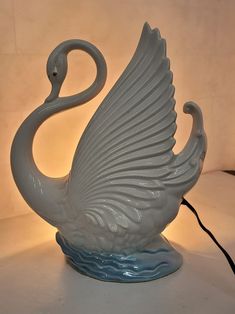 a white swan lamp sitting on top of a table