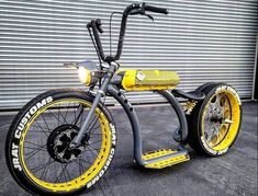 a yellow and black scooter parked in front of a garage door