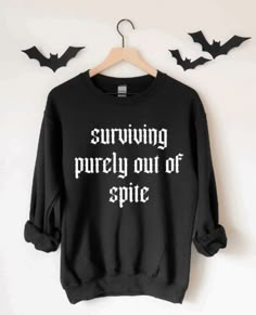 a black sweatshirt with the words surviving purely out of spice printed on it and bats in the background