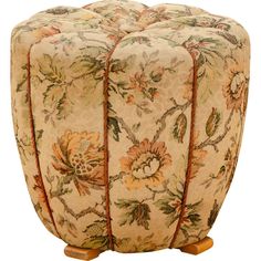 the footstool is made from fabric with flowers and leaves on it's sides