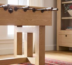 a close up of a wooden table in a room with a rug on the floor