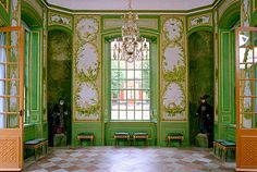 an ornate room with green walls and gold trimmings, painted in shades of green